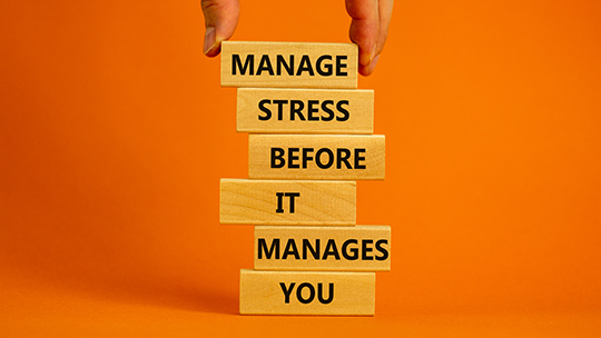 Wooden blocks with words on them. Text reads, "Manage stress before it manages you."